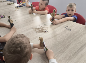 Dzieci podczas pracy nad samodzielnie wykonywaną laleczką z sitowia
