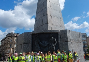 Grupa dzieci stojąca przy pomniku Tadeusza Kościuszki