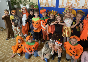 Grupa jagód ustawiona do zdjęcia w jesiennych przebraniach