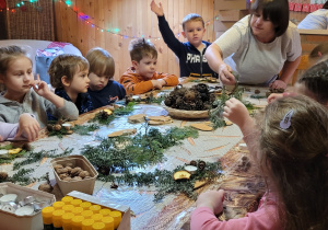 Dzieci wykonują stroiki świąteczne.