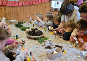 Dzieci wykonują łańcuchy świąteczne.