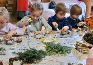 Dzieci wykonują łańcuchy świąteczne.