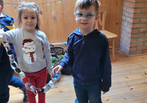 Dwoje dzieci demonstruje długość łańcucha.