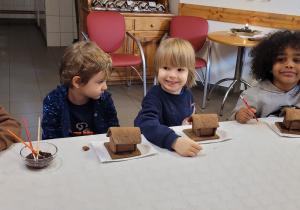 Dzieci wykonują domki z pierników.