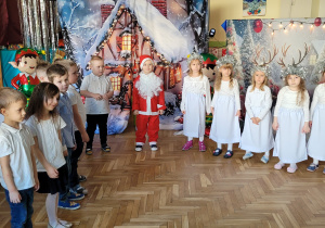 Dzieci stoją w półkolu i wspólnie śpiewają utwór "Już blisko kolęda"