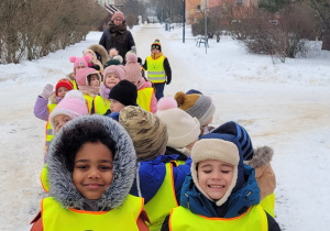 Dzieci z grupy Zajączków idą na zimowy spacer