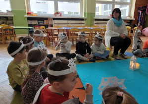 Dzieci przekazują sobie w kręgu lampkę zapachową i zapoznają się z zapachem mięty.