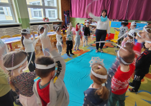 Dzieci tańczą z białymi wstążkami.