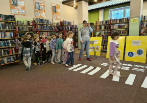 Dzieci utrwalające zasady bezpiecznego przechodzenia przez przejście dla pieszych