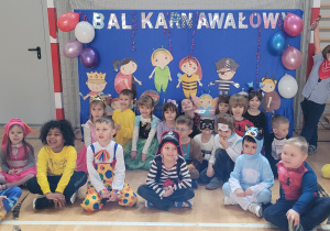 Grupa Zajączki w przebraniach karnawałowych pozuje do grupowego zdjęcia na sali gimnastycznej.