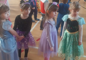 Dzieci z grupy Zajączki tańczą w parach na balu karnawałowym.