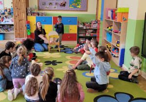 Chłopiec pokazuje reszcie grupy wylosowany przez siebie kolor za pomocą gestu, a pozostałe dzieci odgadują nazwę koloru.