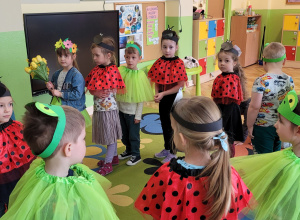 Dzieci w przebraniach wiosennych tańczą przy piosence "Maszeruje wiosna".