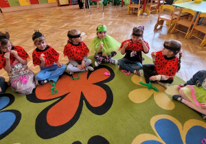 Dzieci siedząc w kręgu degustują smak cytryny i wypowiadają się na temat jej smaku.