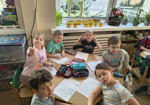 Dzieci przy stolikach kolorujące ilustracje skarpetek