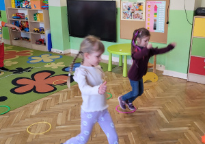 Dwie dziewczynki skaczą z koła do koła.