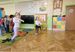Dzieci skaczą jak zajączki i układają marchewki wewnątrz koła.