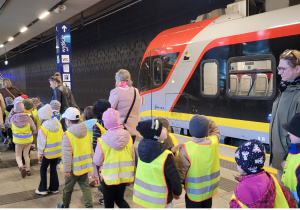 Dzieci idą wzdłuż pociągu na stacji Łódź Fabryczna.