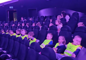 Dzieci siedzą na fotelach w Planetarium.