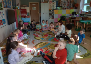 Mama jednego z dzieci, czyta wiersze Juliana Tuwima grupie dzieci w klasie.