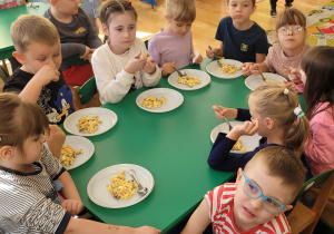 Dzieci jedzą sałatkę, którą same wykonały.
