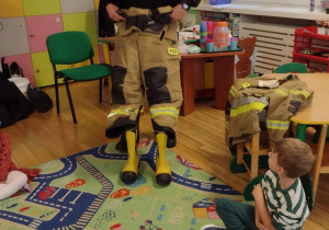Strażak pokazuje swój strój do wyjazdu do pożaru