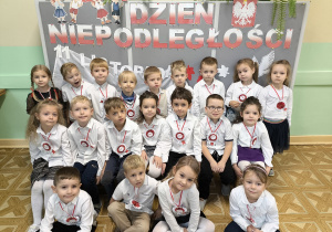 Grupowe zdjęcie dzieci na tle napisu Dzień Niepodległości.