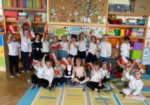 Grupowe zdjęcie dzieci machających flagą narodową Polski
